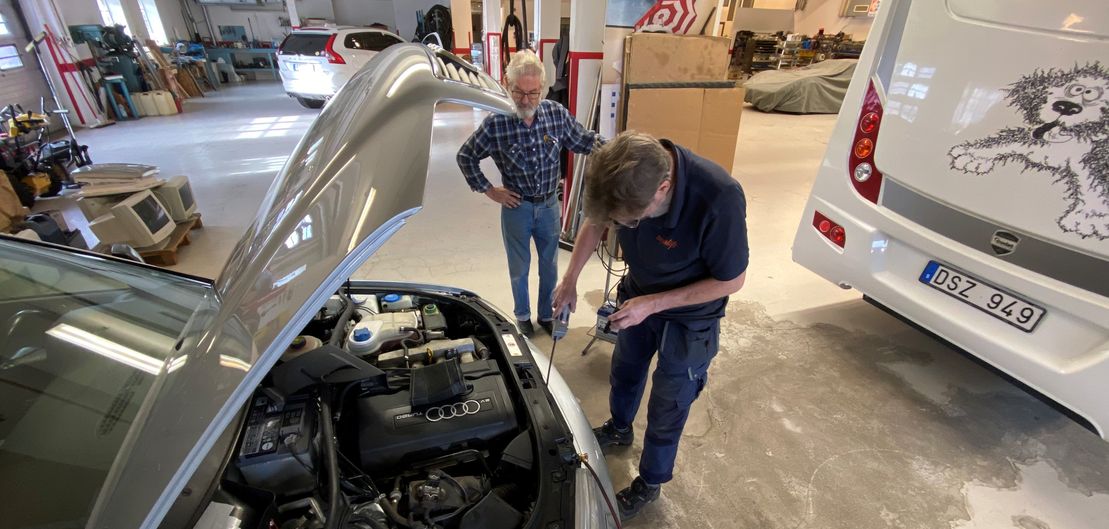 Anställd på Segerlöfs utför en AC-service på en bil.